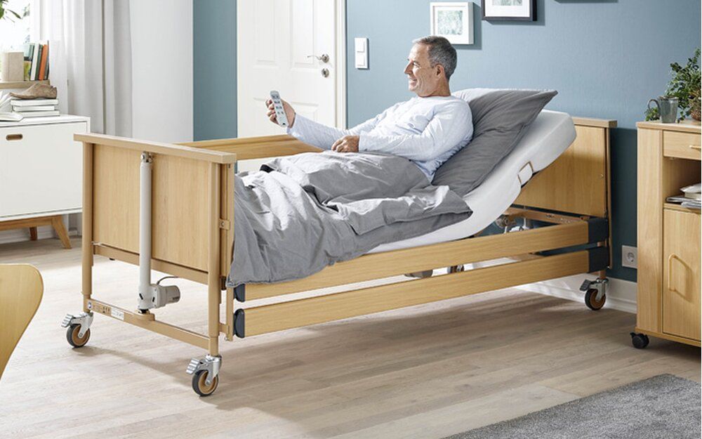 Pflegebett mit Patient in modern eingerichtetem Raum