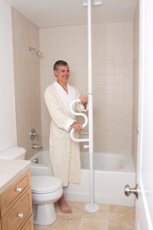 Mann hält sich sicher im Bad an einer Boden-Deckenstange fest